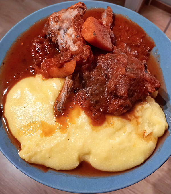 polenta fioretto inondata da abbondante sugo di coniglio